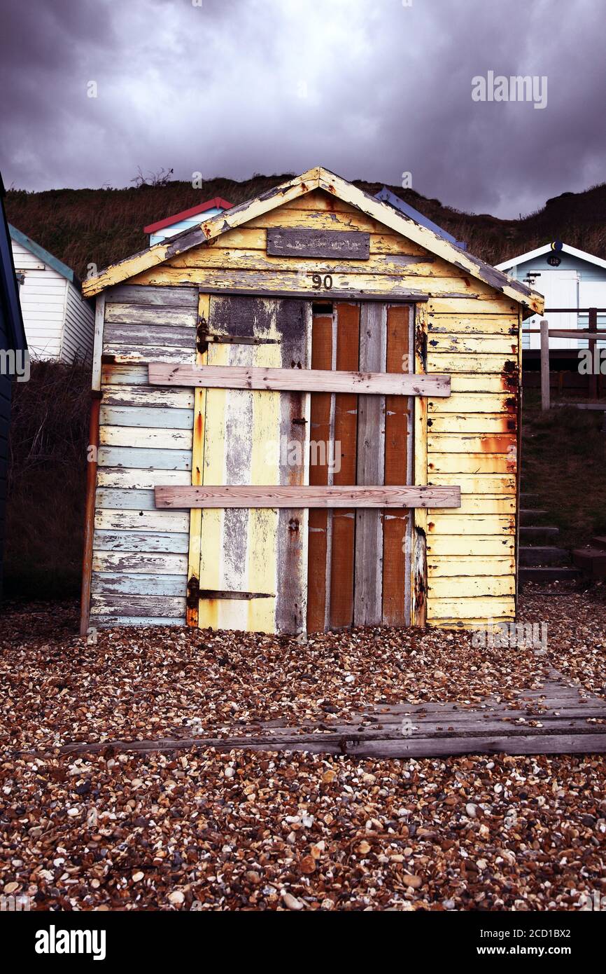 Weathered dilapidated and aged grim old wooden rustic beach hut in bad weather. Long abandoned and boarded up. Stock Photo