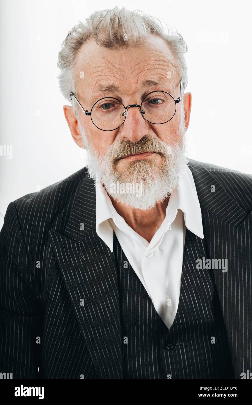 Pensive bearded grey haired stylish elderly business man in formal black  suit, no tie, being deep in thoughts, looks aside, isolated over dark Stock  Photo - Alamy