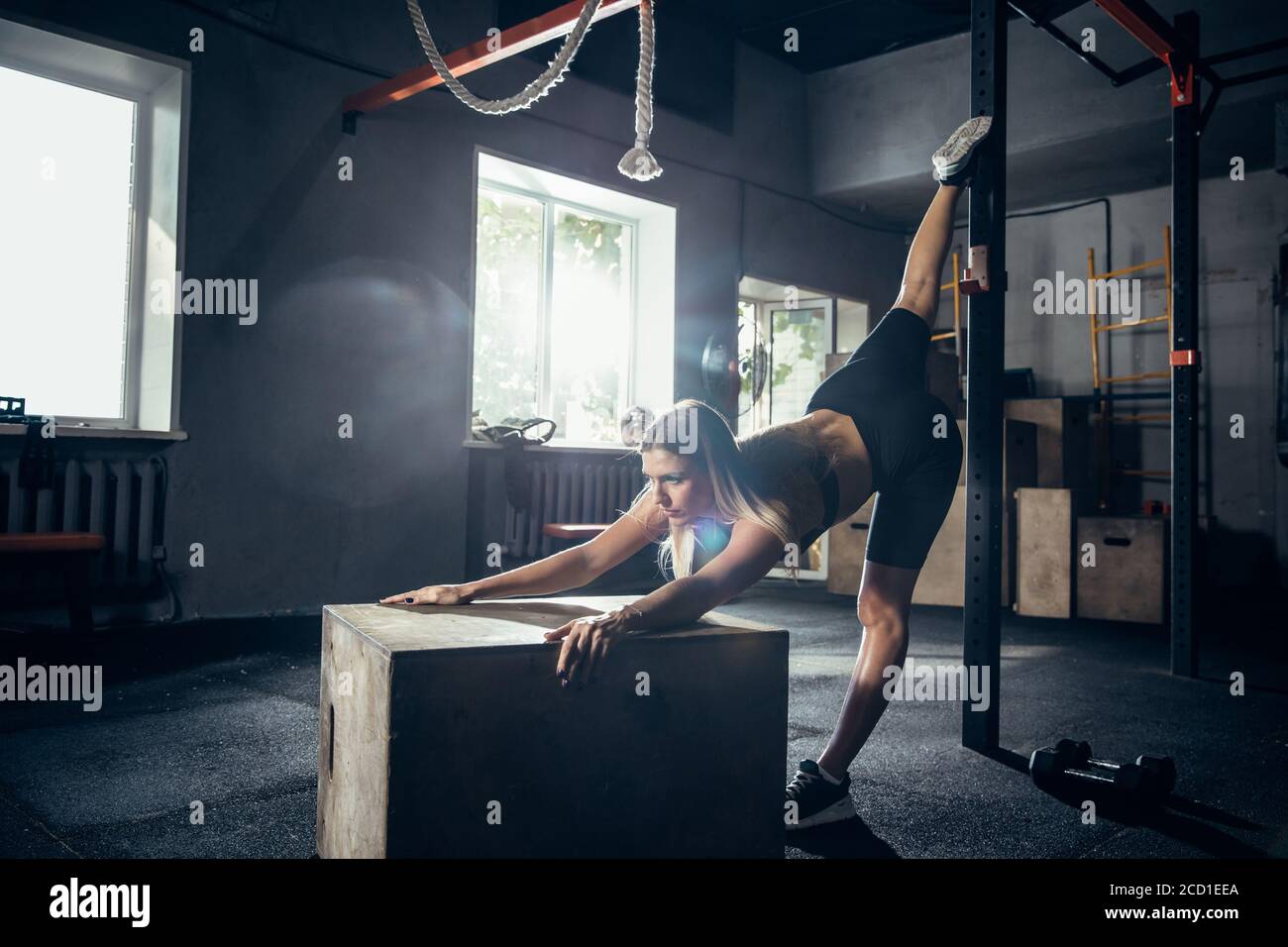 Stretching. Young caucasian female athlete training in gym, doing ...
