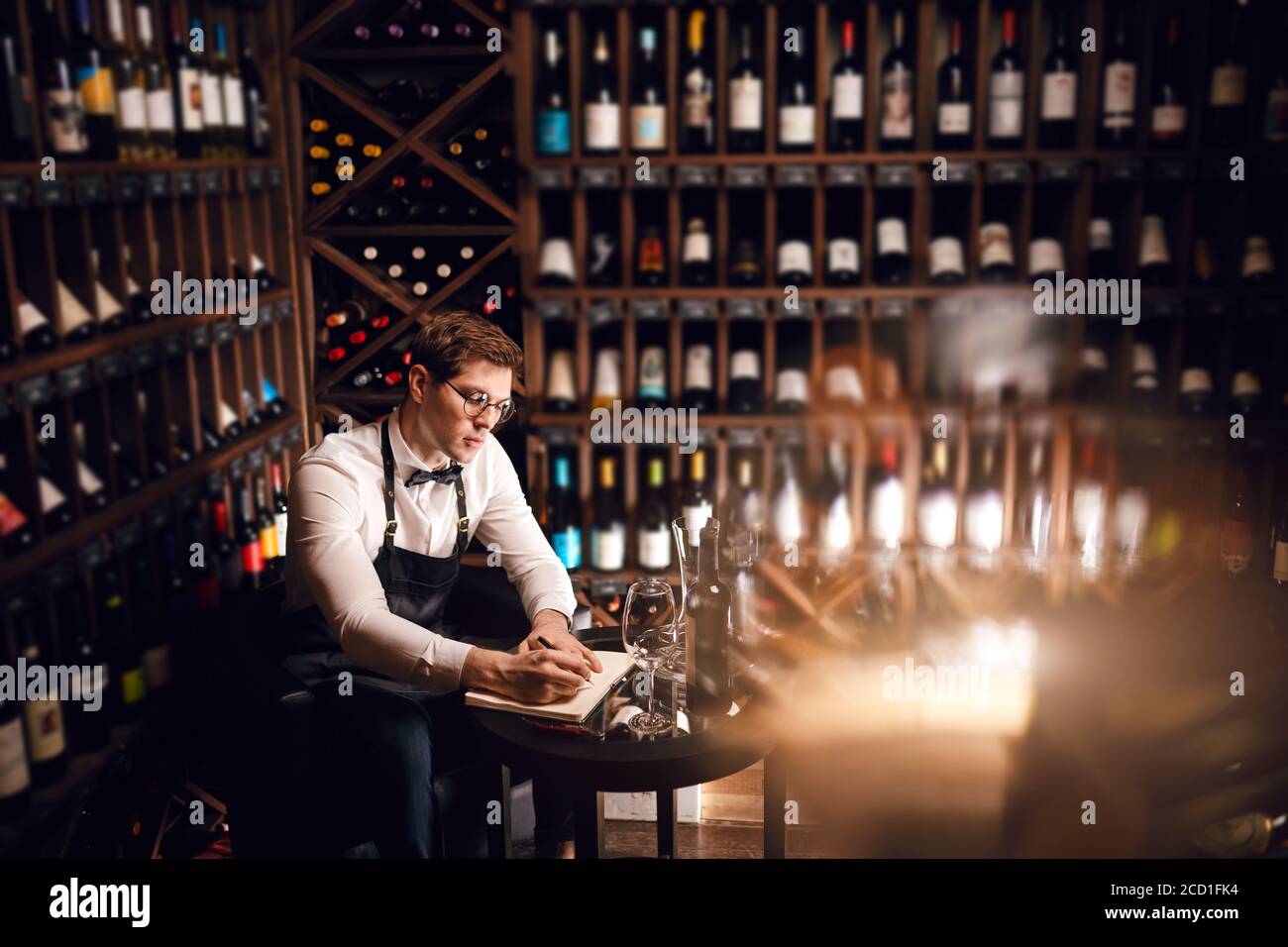 Elegant wine seller holding a bottle of wine and reading label in a