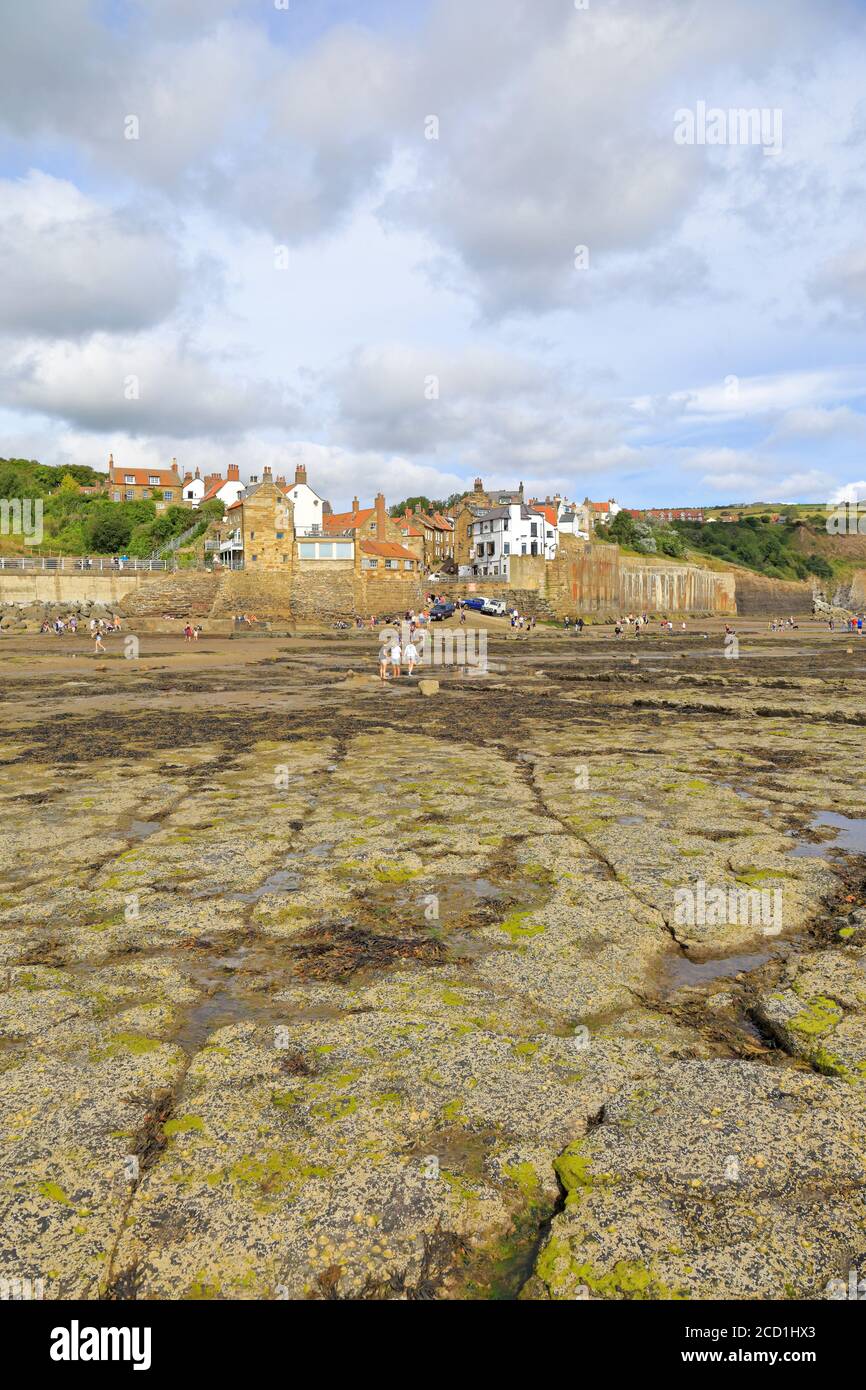 Tourists on the foreshore at low tide at Robin Hoods Bay, North Yorkshire, North York Moors National Park, England, UK. Stock Photo