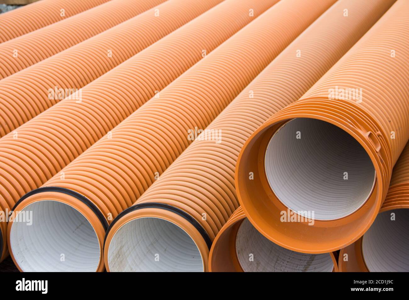 Sewer plastic pipes of orange color at a construction site. Construction  Materials. Pipes for water supply Stock Photo - Alamy