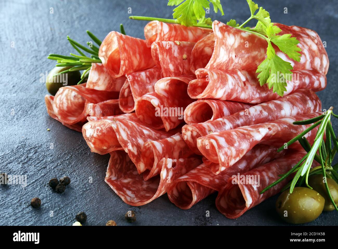 thinly sliced salami. delicious snack rustic salami Stock Photo - Alamy