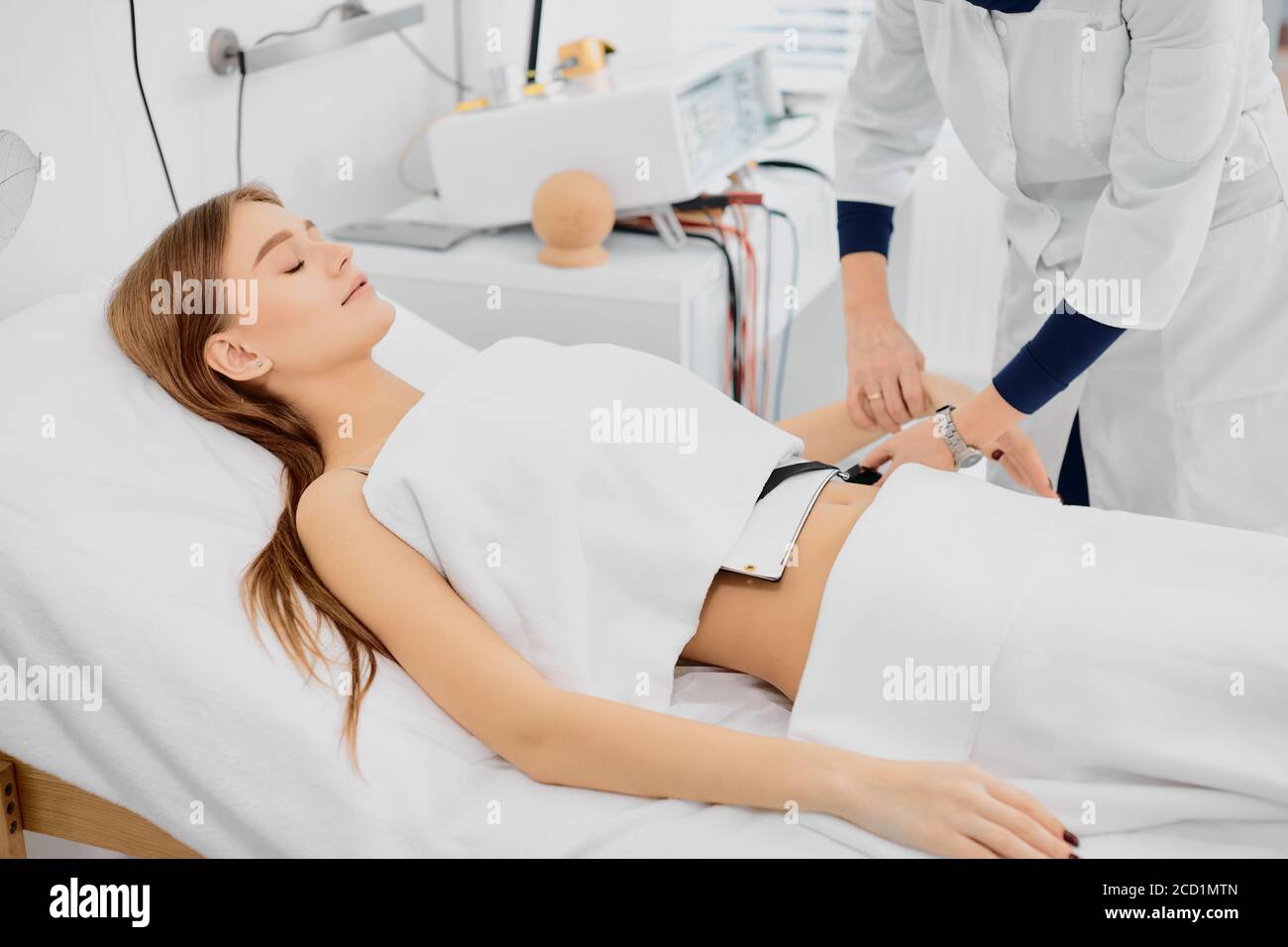 young female lying on bed treating stomach disease, beautiful caucasian woman in hospital Stock Photo