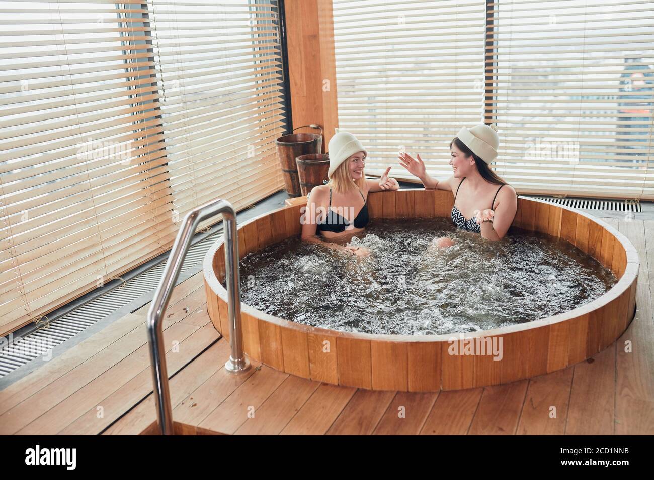 Group of happy people young people having great time in spa, relaxing enjoying jacuzzi hot tub