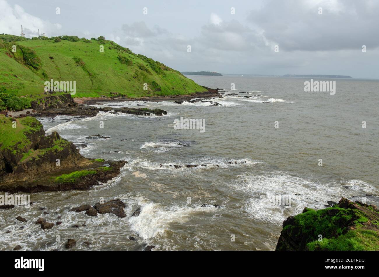 Monsoon Season view of the rough Arabian Sea and Rocky Shoreline near Lower Aguada or also called Devil's Finger, Sinquerim, Goa, India Stock Photo