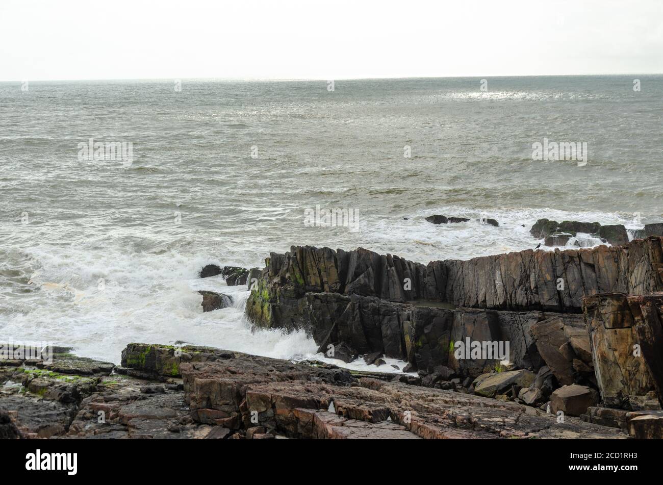 Monsoon Season view of the rough Arabian Sea and Rocky Shoreline near Lower Aguada or also called Devil's Finger, Sinquerim, Goa, India Stock Photo