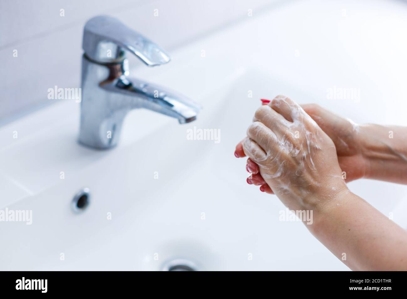 Woman washing hands with soap in bathroom Stock Photo - Alamy