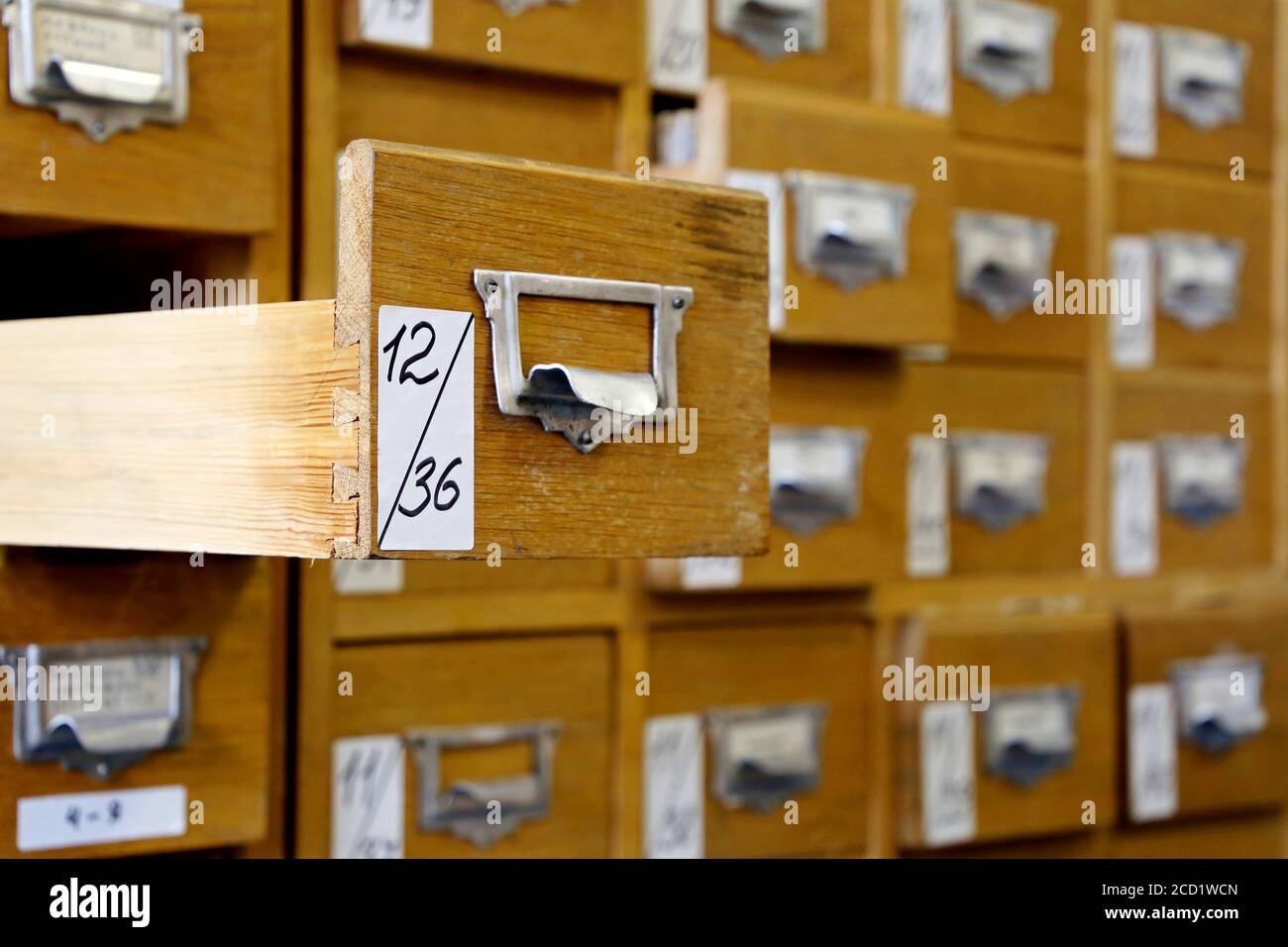 Library catalogue cards in old wooden box. File archive, opened drawer with paper documents, database concept Stock Photo