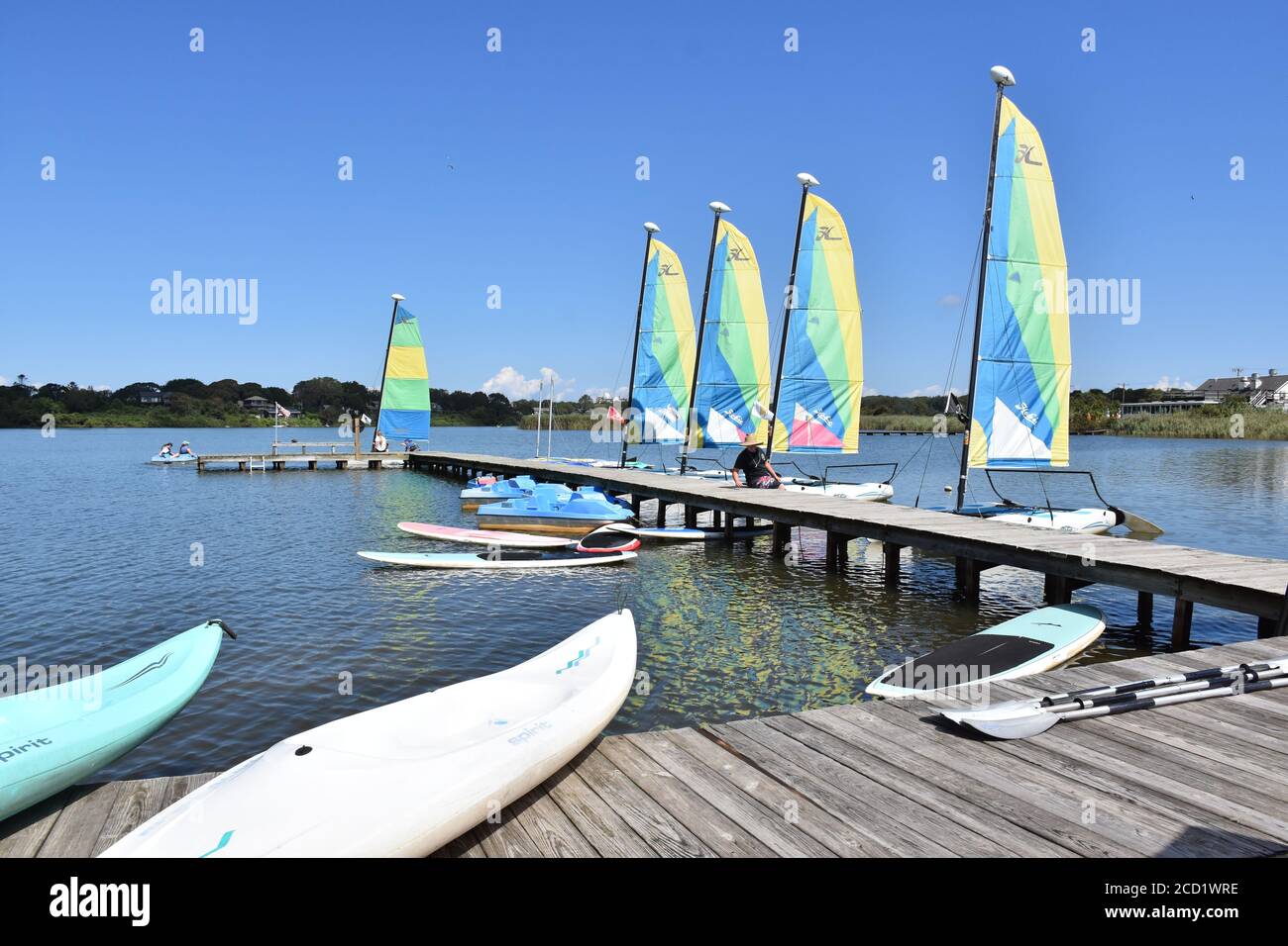 Kayaks, Paddleboards and sailboats at the lake Stock Photo