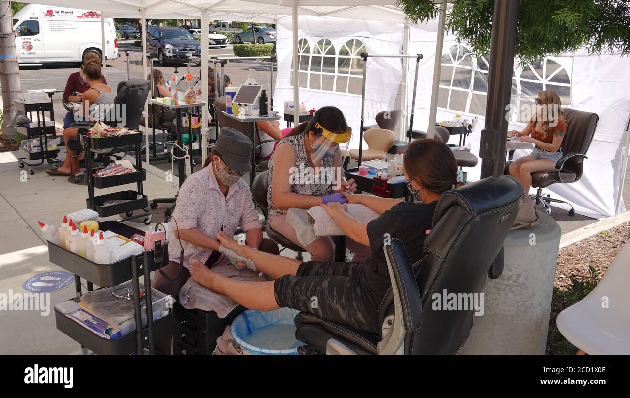 Vista, CA / USA - August 1, 2020: A nail salon has moved its operations outside to avoid having to close again during times of Covid-19. Stock Photo