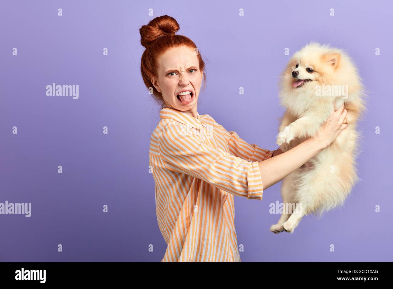 nervous girl showing her tongue , her dog has pooped,peeded itself, dog