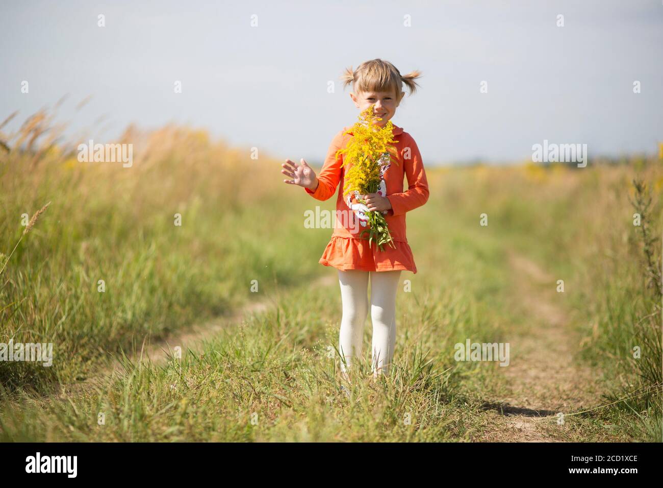 Adorable little girl holding a bouquet of yellow wildflowers Stock ...