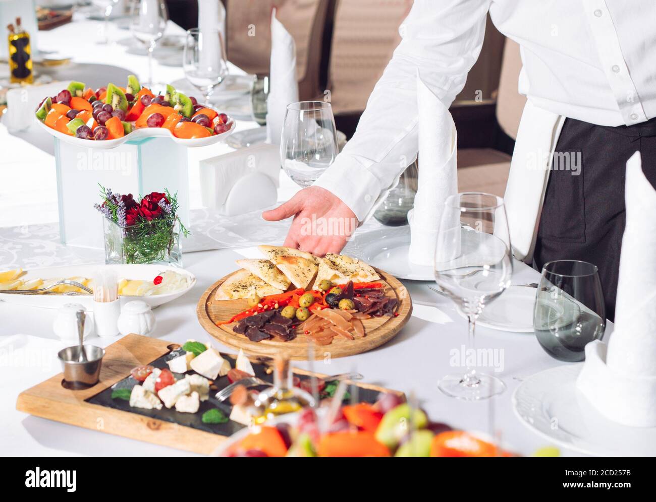 Waiter serving table in the restaurant preparing to receive guests
