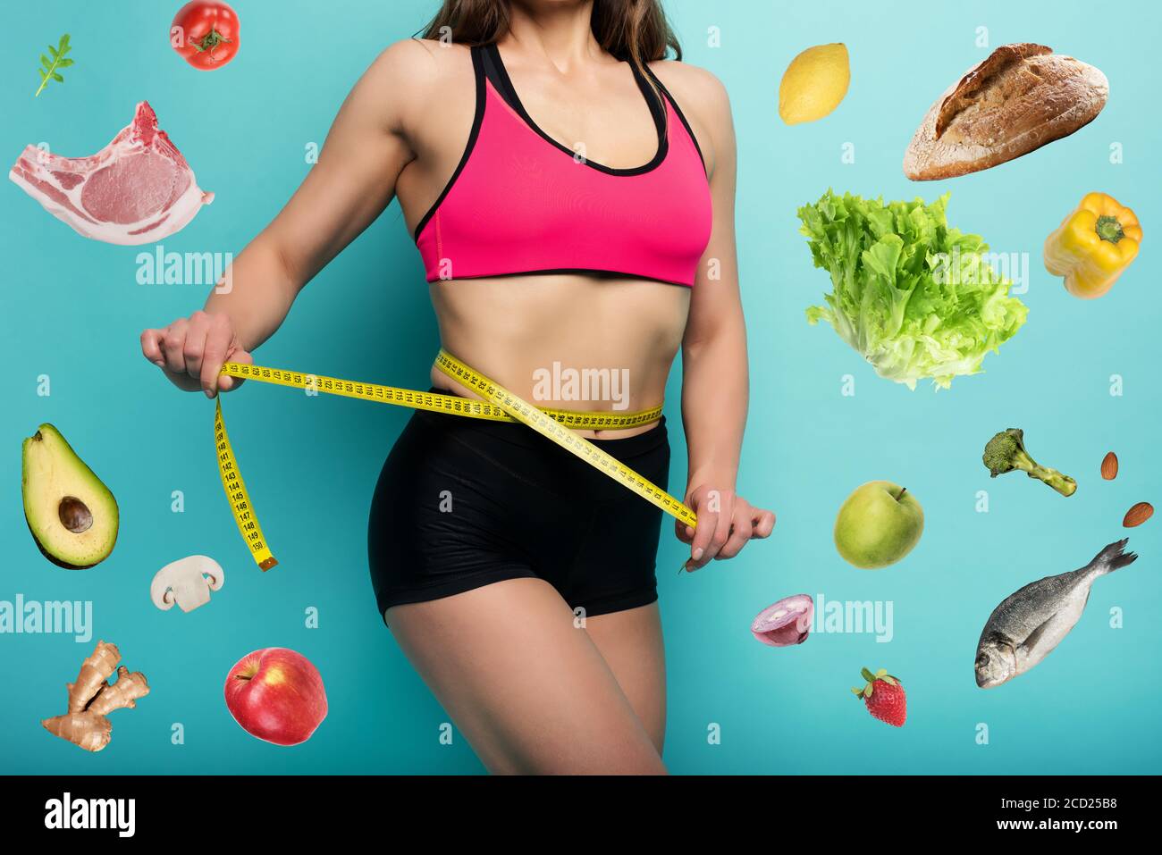 Determinated Sport woman has an excellent physical shape and measure with the meter. Cyan background Stock Photo