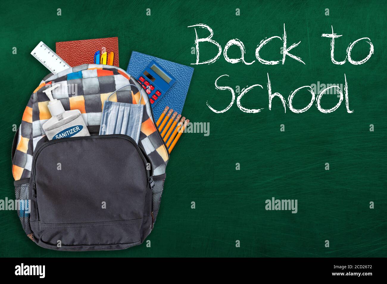 Back to school education concept in the new normal during Covid-19 pandemic with backpack stuffed with stationery, hand sanitizer and face mask on cha Stock Photo