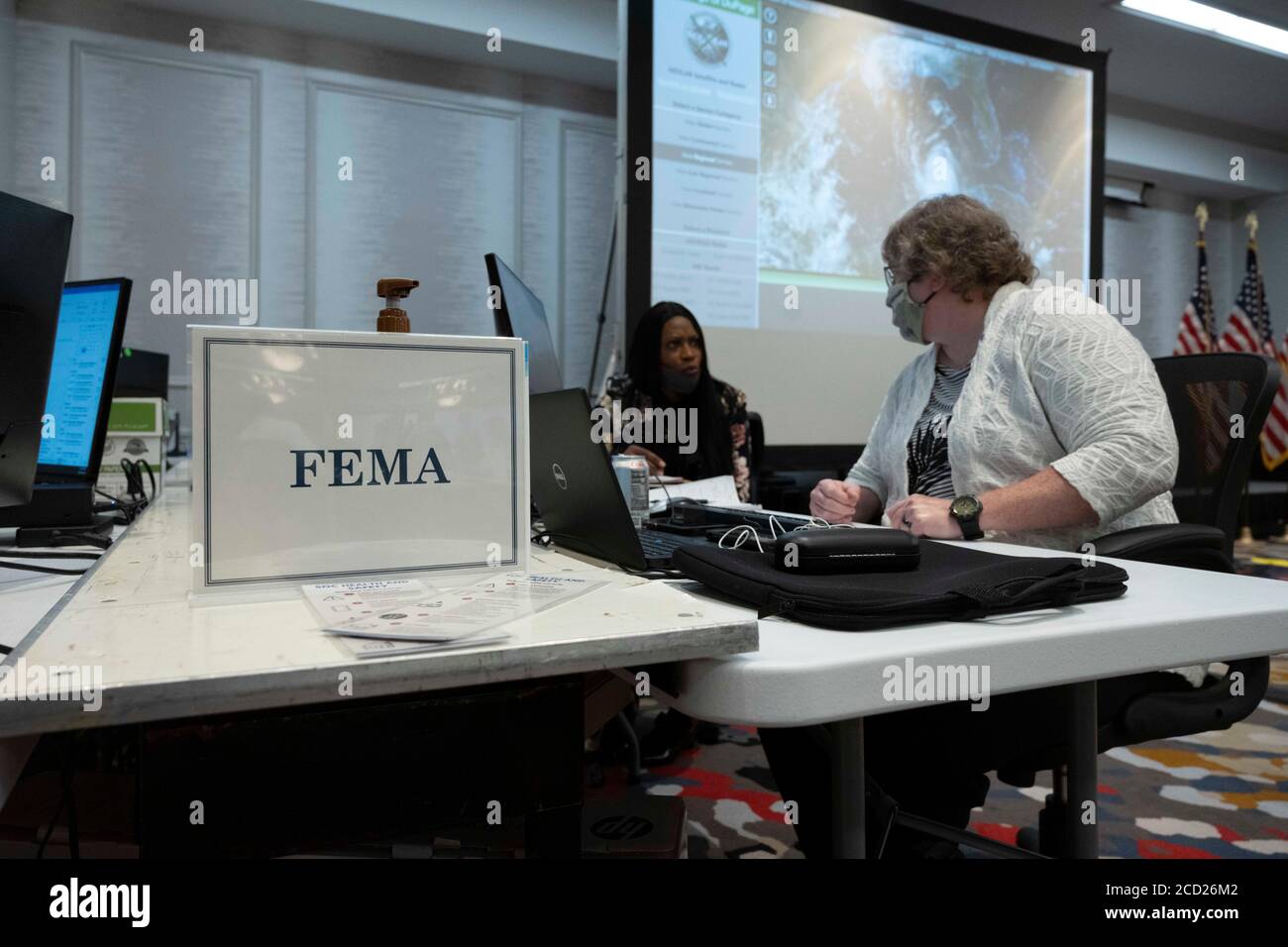 Austin, Texas, USA. 25th Aug, 2020. Texas officials gather data in the state Emergency Operations Center (EEOC) in a local hotel as Governor Greg Abbott (not shown) briefs the press on Texas' preparations for Hurricane Laura, scheduled to make landfall in east Texas and coastal Louisiana on Thursday. Abbott mobilized hundreds of state resources as Texans remember the extreme damage done by Hurricane Harvey in 2017. Credit: Bob Daemmrich/ZUMA Wire/Alamy Live News Stock Photo