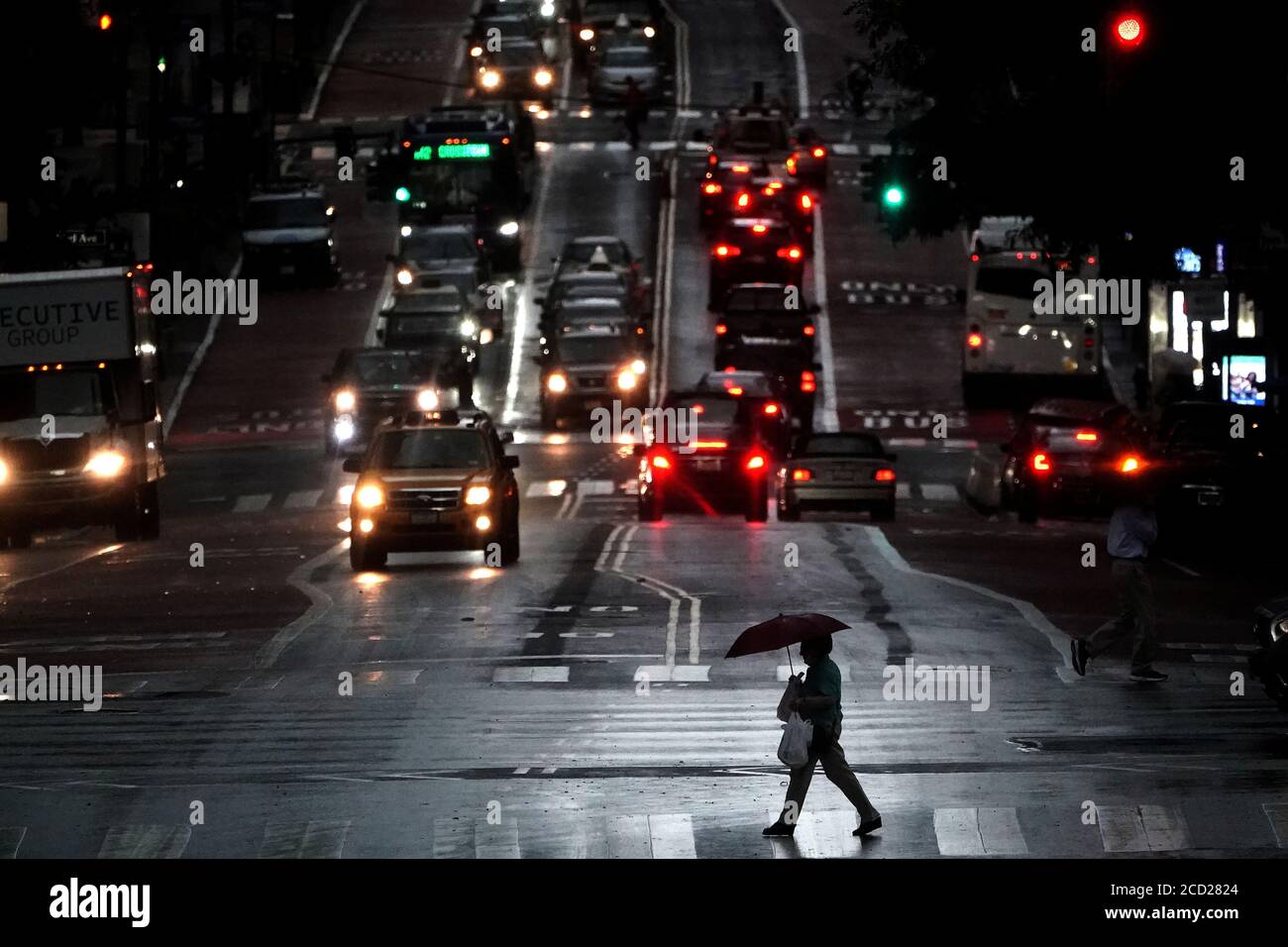A person with an umbrella walks down 2nd Ave at 42nd street as it rains in the Manhattan borough of New York City, New York, U.S., August 25, 2020. REUTERS/Carlo Allegri Stock Photo