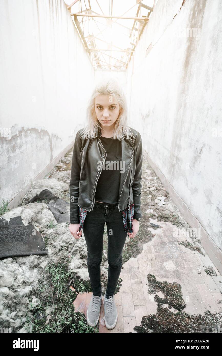 Pretty blond young woman standing in ruined corridor Stock Photo