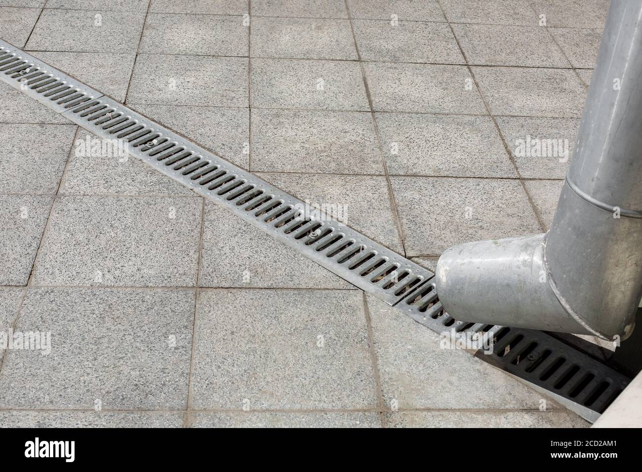 an engineering structure a downspout with a drainage grate for drainage of rainwater against a