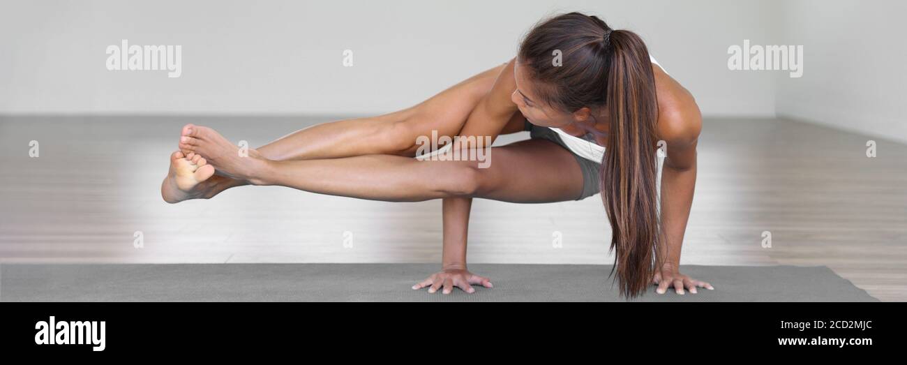 Yoga banner fitness woman training arm balance doing eight angle pose exercise on fitness mat at gym studio. Health yoga lifestyle. Stock Photo