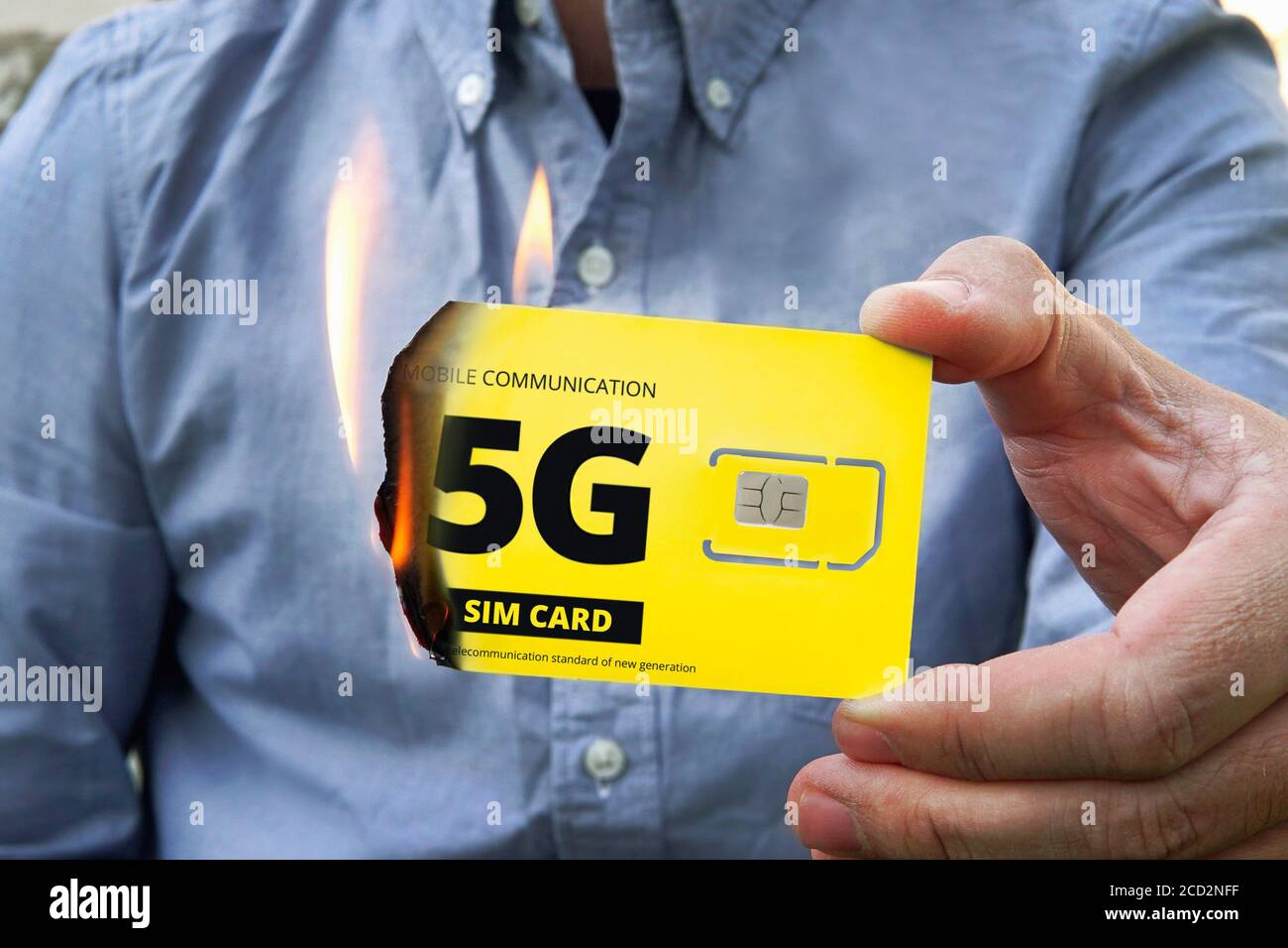 A paranoid man burns a 5G SIM card for fear of harmful radiation. Fighting high-speed Internet 5 g. Destruction of 5P tower technologies. Retrograde r Stock Photo