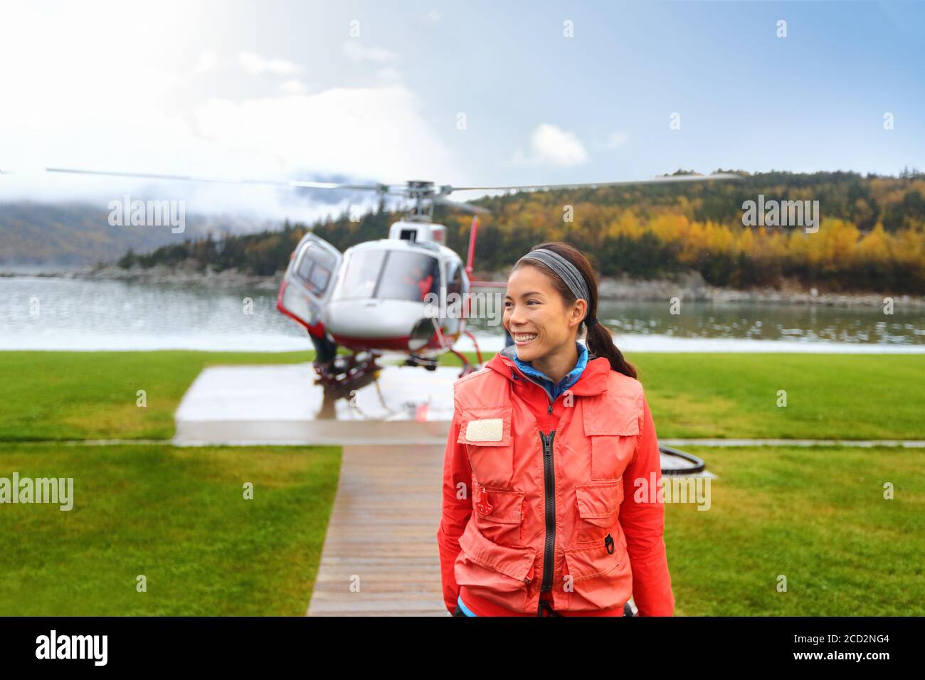 Happy helicopter tourist woman on Alaska tour excursion. Asian girl tourist cruise passenger on shore activity doing helicopter ride in Alaska, USA. Stock Photo