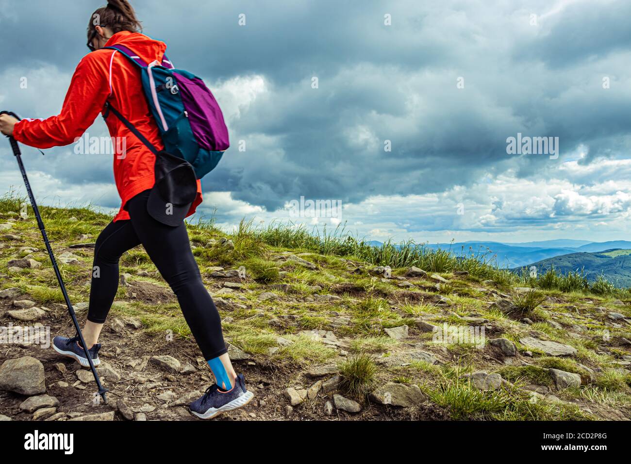 Girl hiking in the mountains with backpack. Walking on mountain
