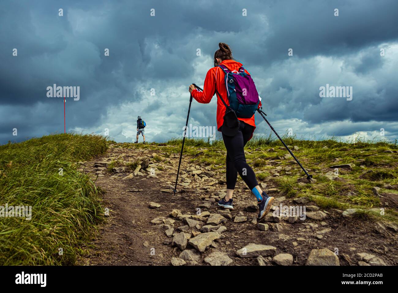 Girl hiking in the mountains with backpack. Walking on mountain path in ...