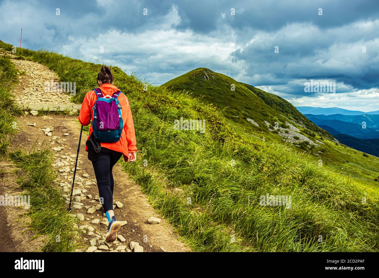 Girl hiking in the mountains with backpack. Walking on mountain path in ...