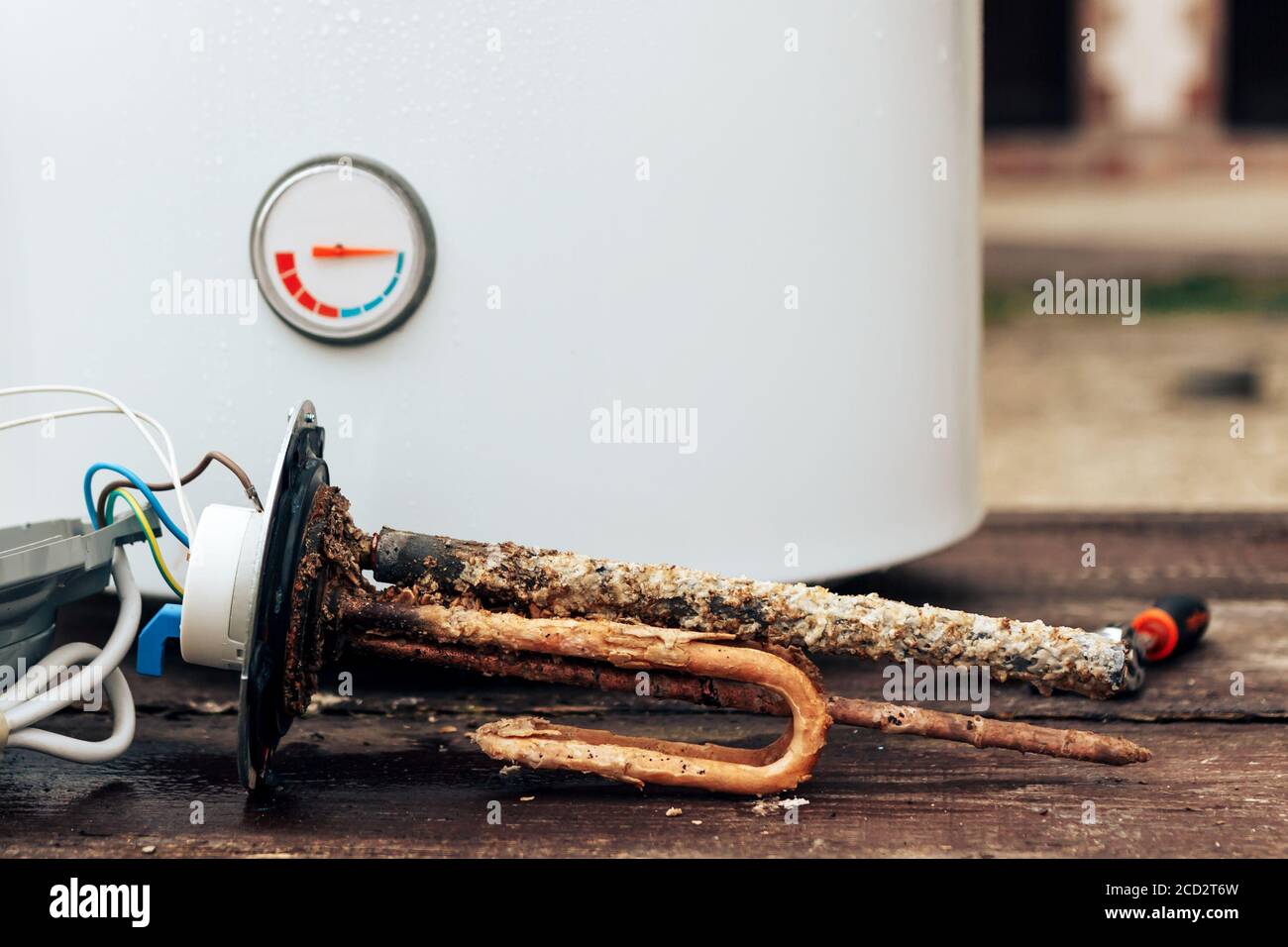 https://c8.alamy.com/comp/2CD2T6W/heating-element-rust-and-scale-on-boiler-background-lying-on-wooden-table-2CD2T6W.jpg