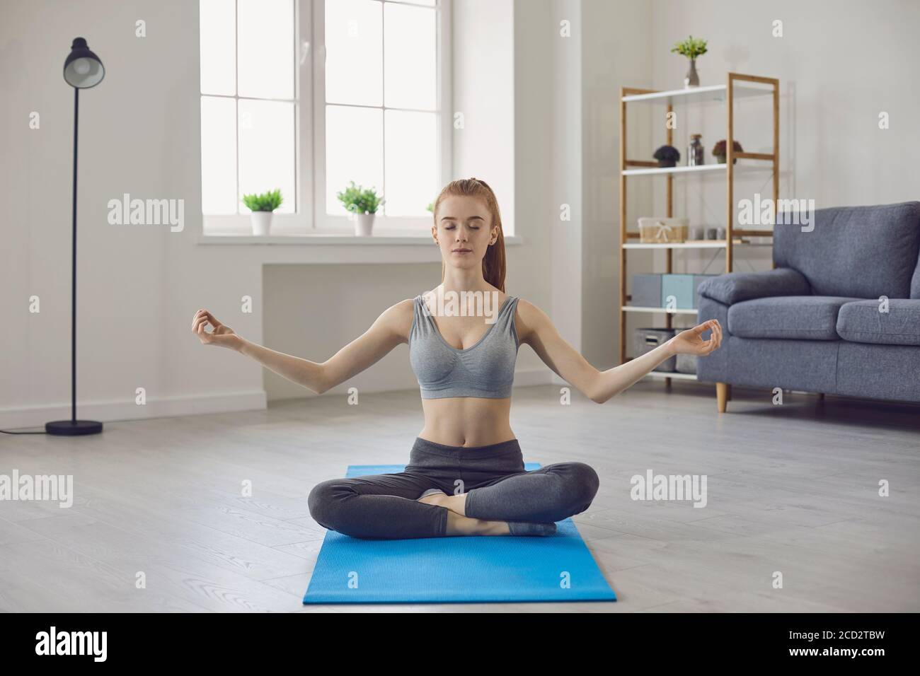 Young girl coach training hatha yoga from home Stock Photo