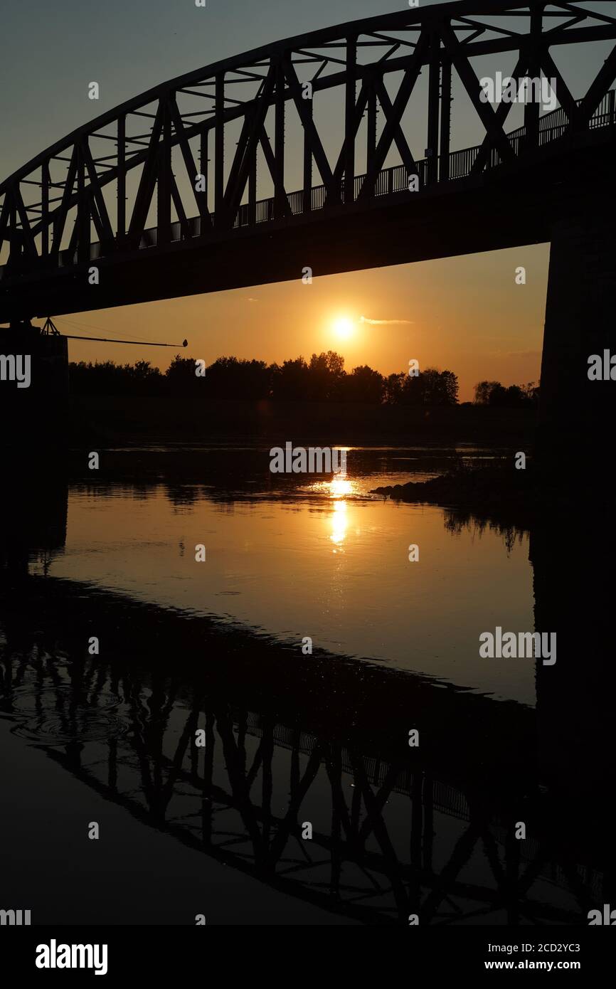 The reflection of the old bridge on the river,The silhouette of the old bridge at sunrise or sunset in the countryside Stock Photo