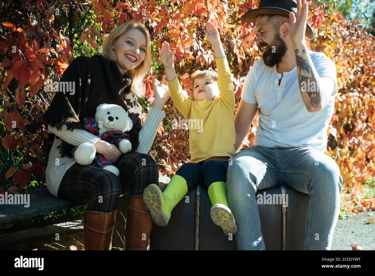 Happy family together. Blonde mom and bearded dad teach baby to be ...