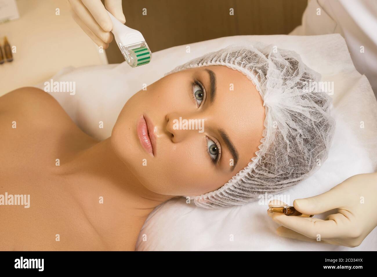 Beautiful woman during facial mesotherapy for smoothing of mimic wrinkles  around eyes. Beautician doing anti-aging injection for rejuvenation and  lift skin Stock Photo