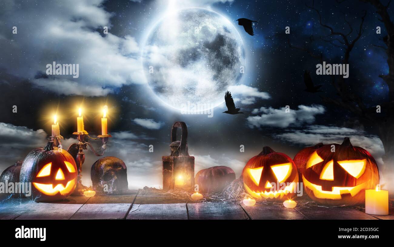 Spooky halloween pumpkin placed on wooden planks. Scary halloween background with free space for text. Stock Photo
