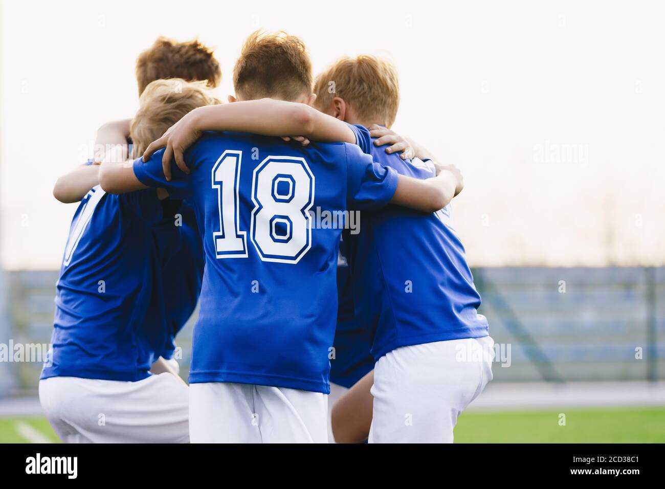 Children Play Sports in a Team. Boys Huddling Before the Game. Kids Sports Team United Ready to Play Match. School Age Boys in Blue Sports Uniforms Stock Photo