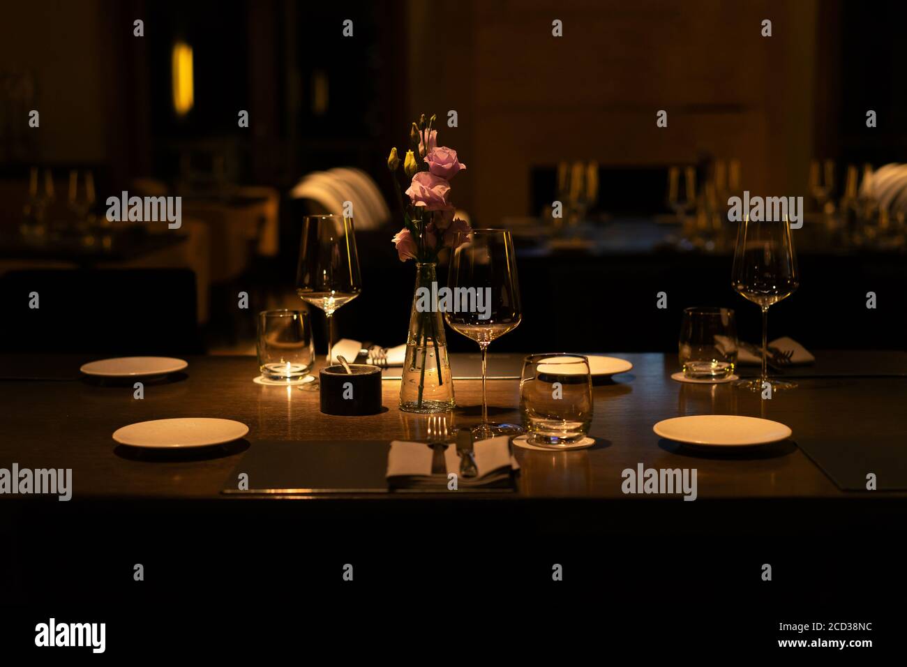 romantic evening table setting with wine glasses and flowers in unrecognizeble restaurant Stock Photo