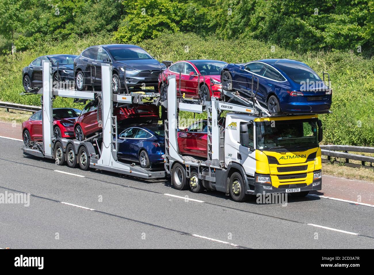 ARS Altman Auto transporter, Tesla american car transporter carrier; Motorway heavy bulk Haulage delivery trucks, haulage, lorry, transportation, collection and deliveries, multi-car commercial vehicle carrier, truck, special cargo, vehicle delivery, transport, industry, freight on the M6 motorway. Stock Photo