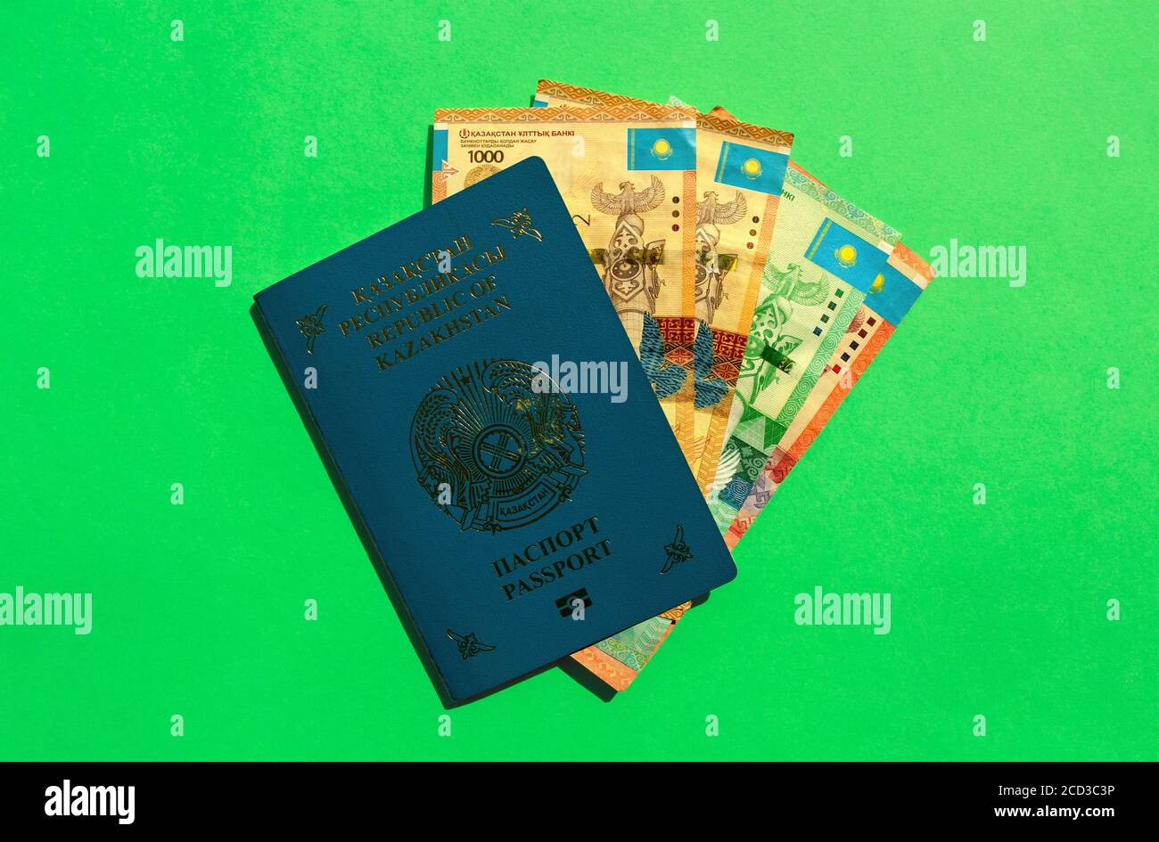 Kazakhstan passport with national money - tenge on green background. KZ passport and kazakh money banknotes. Stock Photo