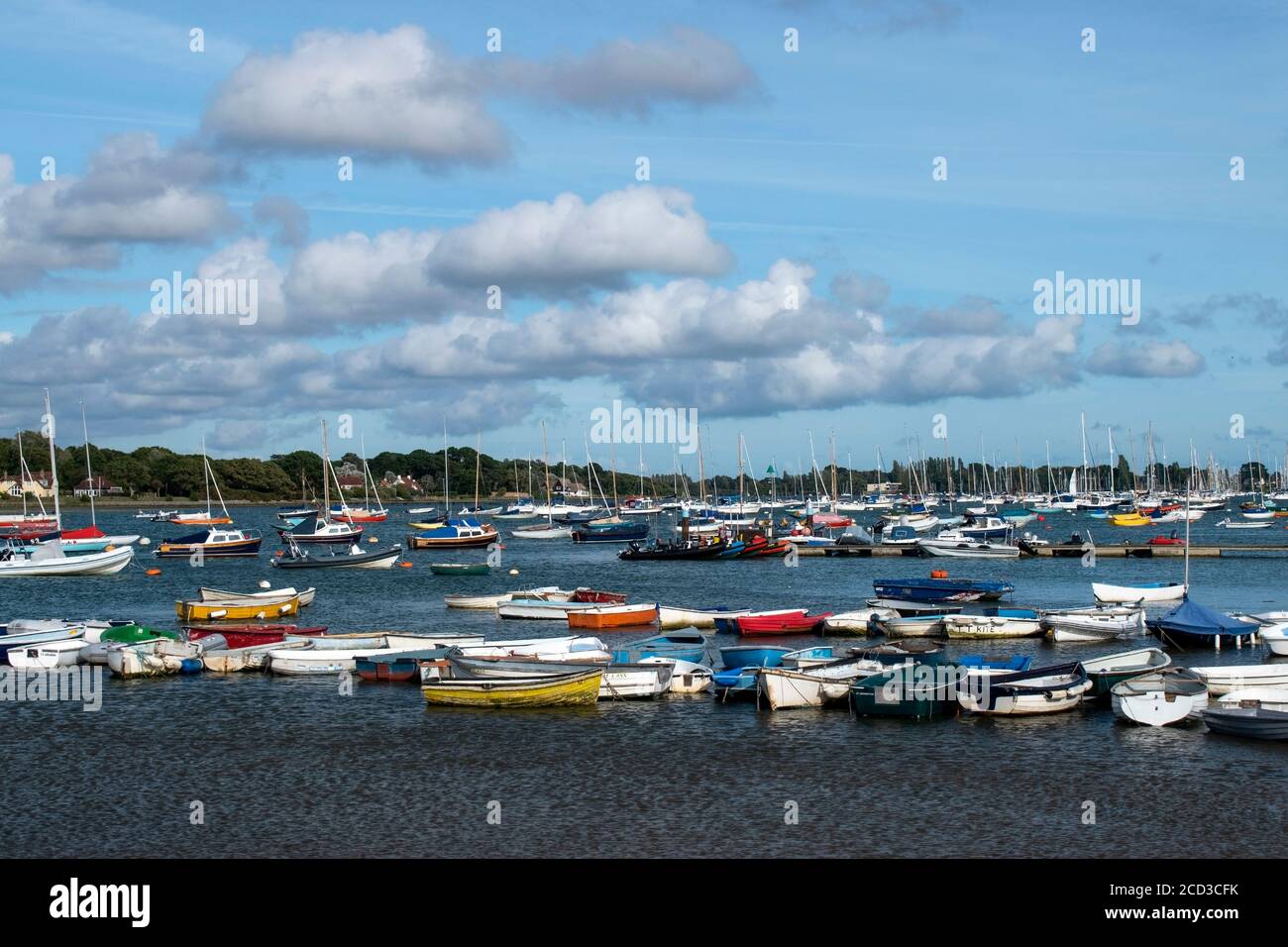 Moored colourful boats at Itchenor with the estuary full of boats. Stock Photo