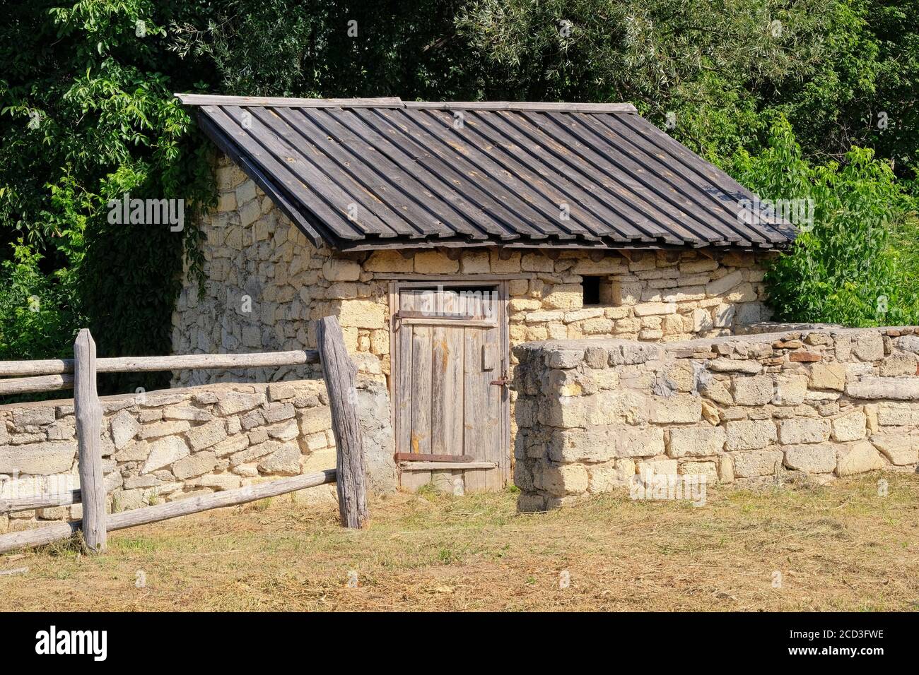 Old rural house with wooden roof and stone walls. European