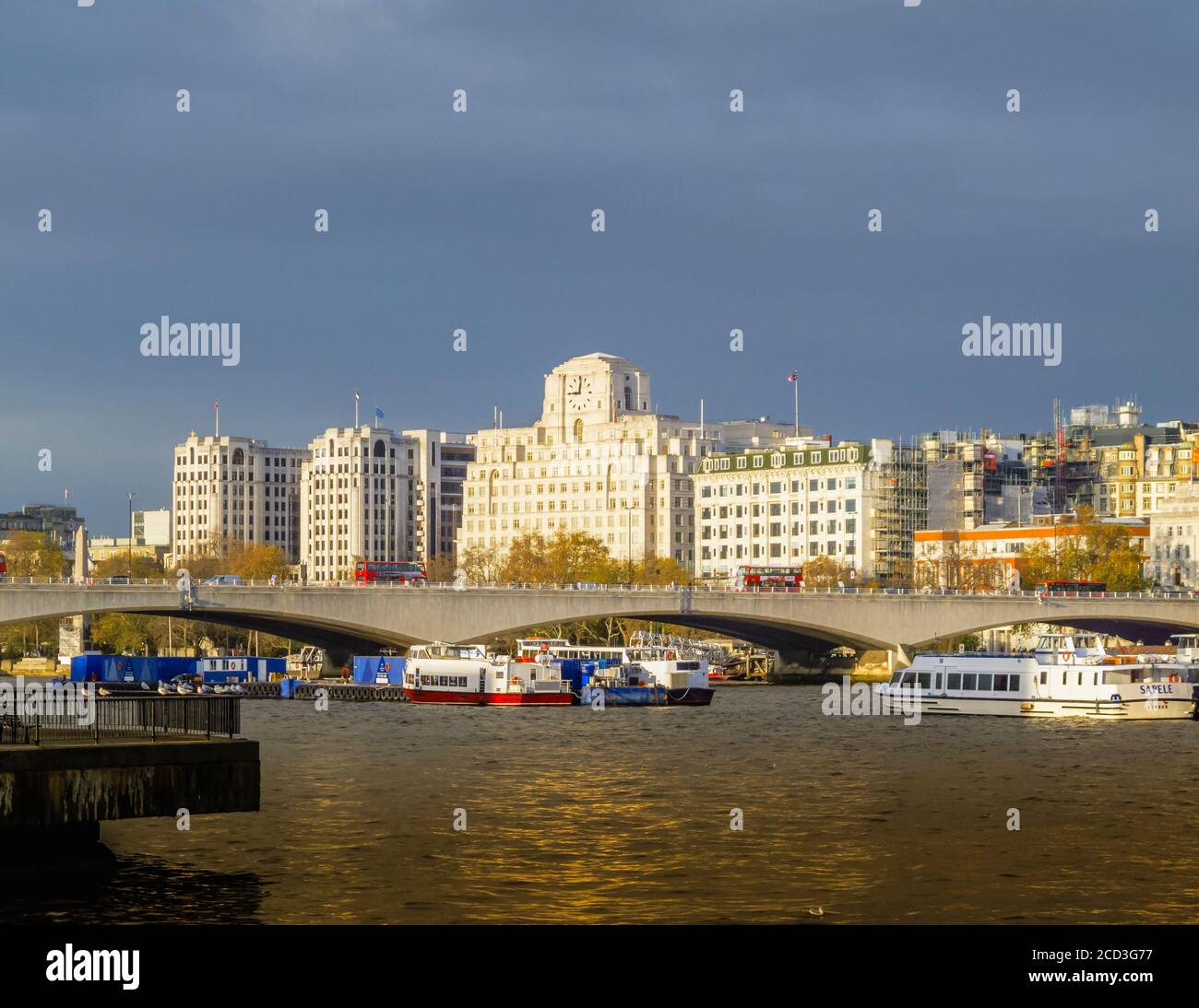 View across the River Thames over Waterloo Bridge to Shell Mex House in morning light in winter under grey skies Stock Photo