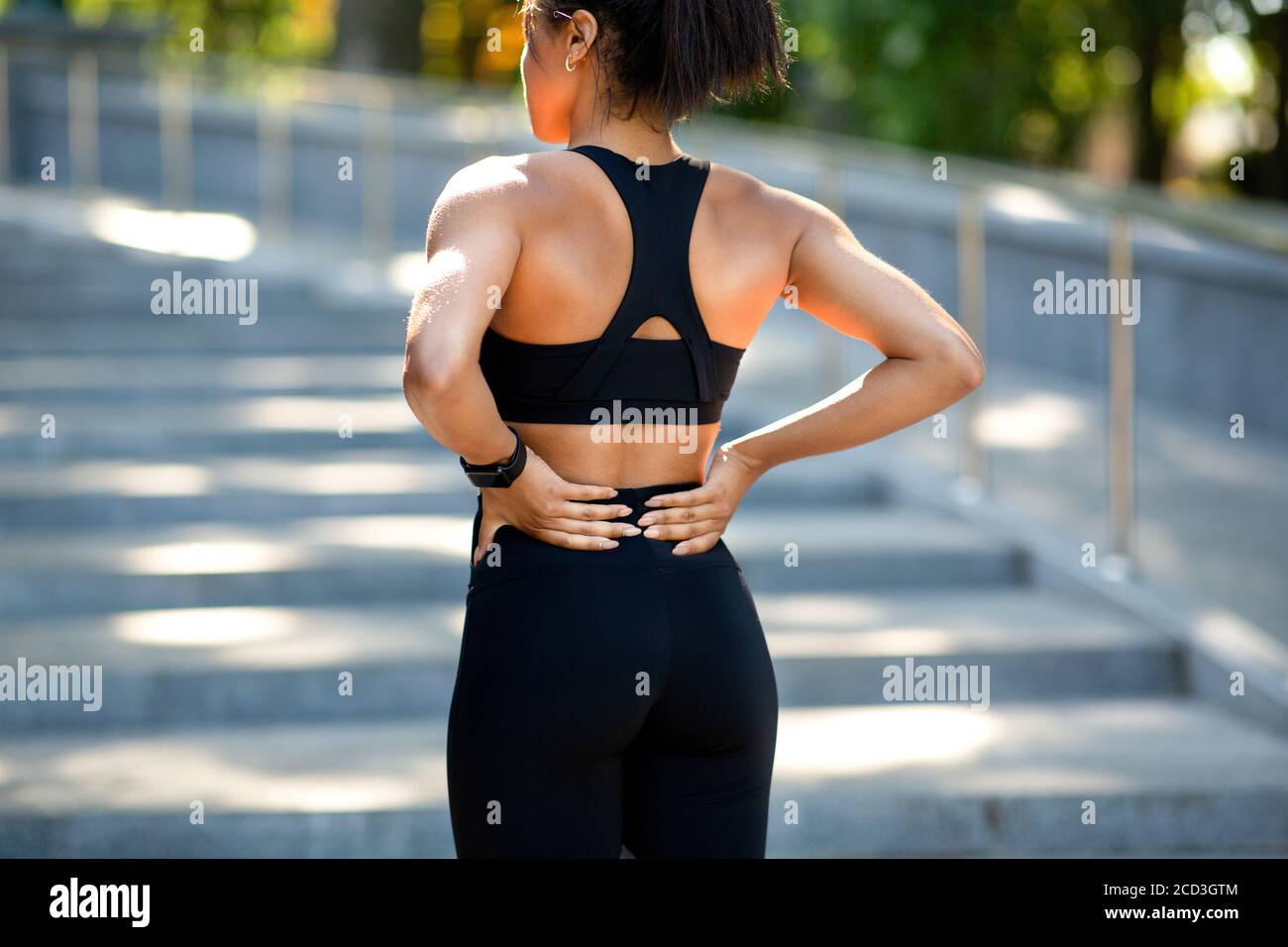Black woman having lower back pain, got hurt during exercising Stock Photo