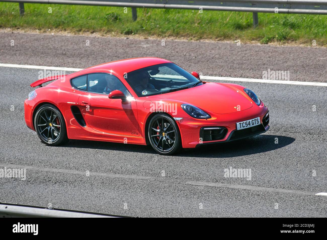 2016 red Porsche Cayman GTS S-A; Vehicular traffic moving vehicles, cars driving vehicle on UK roads, motors, motoring on the M6 motorway highway network. Stock Photo