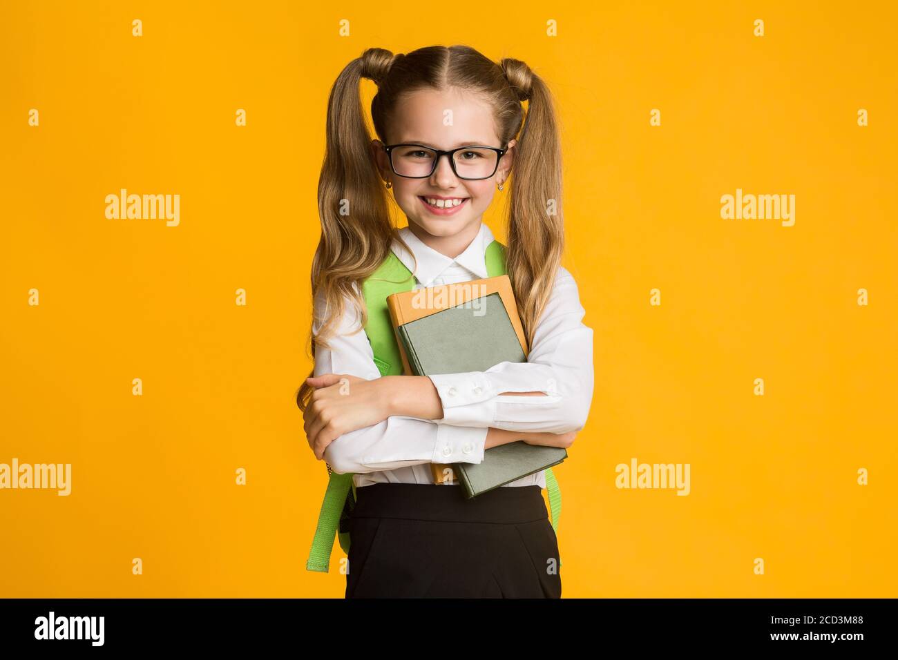 Hugging Books Smiling Elementary Student Girl Hugging Books On Yellow Studio ...