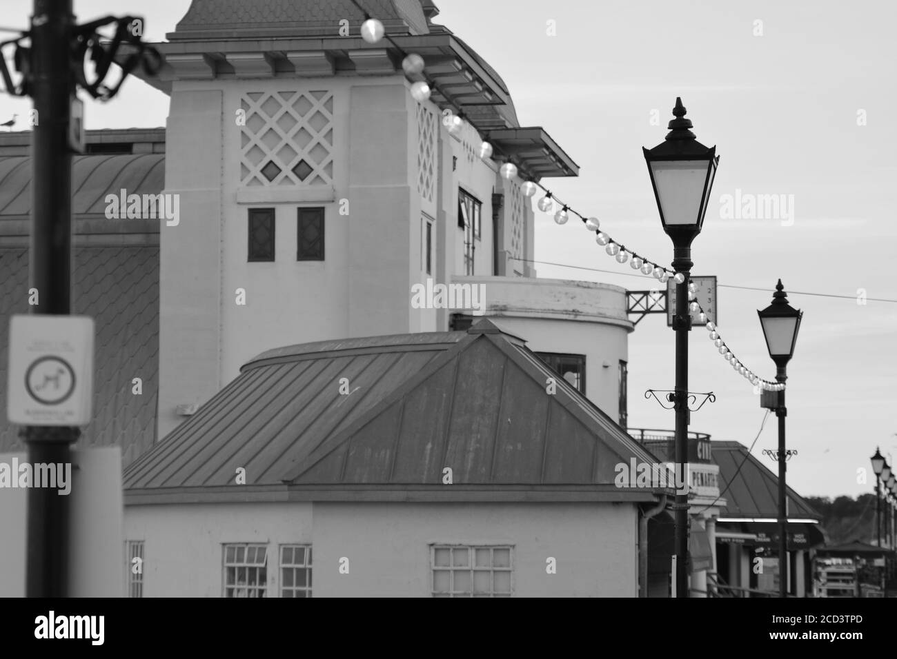 The sun has set, people enjoy an evening stroll along Penarth promenade and pier. Penarth