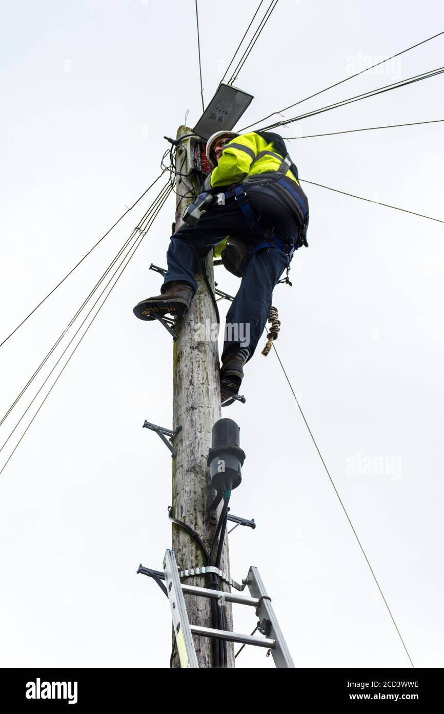 Eir telecoms engineer works on lines up a pole in Ardara, County Donegal, Ireland Stock Photo