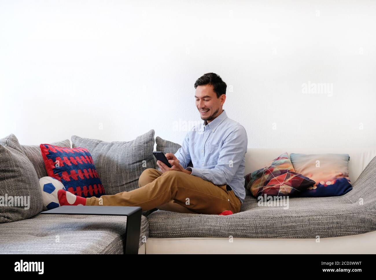 Smiling man typing on smartphone Stock Photo