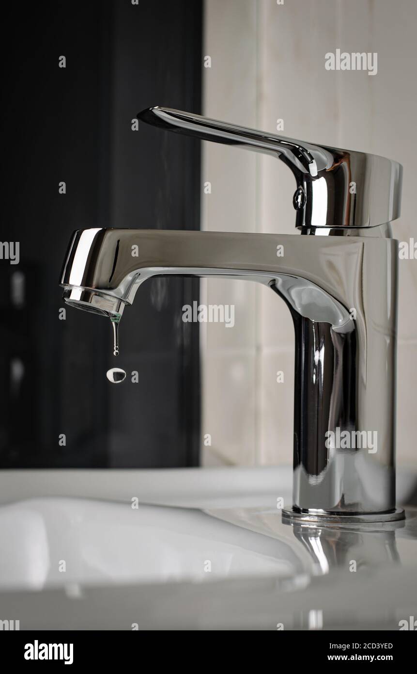 Water tap, faucet dripping in bathroom. Close up, vertical Stock Photo ...
